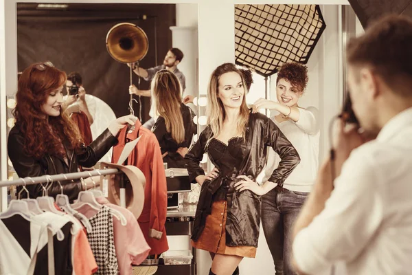 Stylist putting clothes on model — Stock Photo, Image