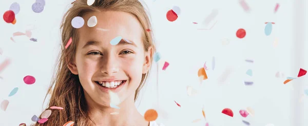 Uśmiechnięta młoda dziewczyna z konfetti — Zdjęcie stockowe