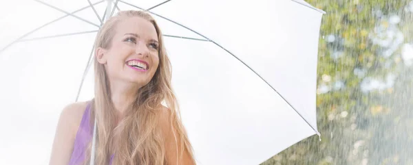 Estudiante sonriente con paraguas durante el paseo — Foto de Stock