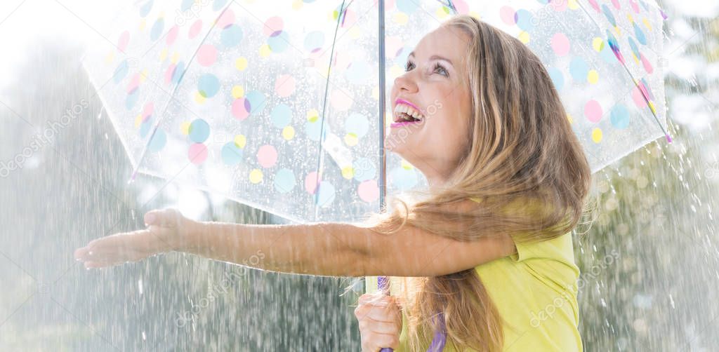 Young blonde girl enjoying rain