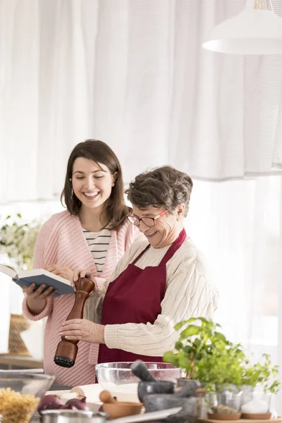 Petite-fille lecture recettes grand-mère — Photo