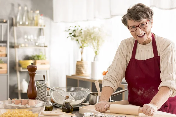 Seniorin rollt Pizzateig — Stockfoto