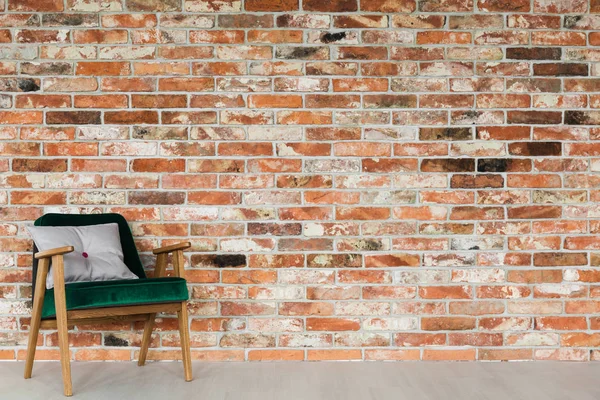 Poltrona verde su muro di mattoni — Foto Stock