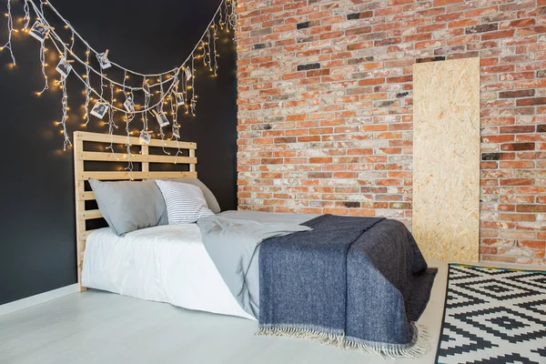 Bed in bedroom with brick wall — Stock Photo, Image