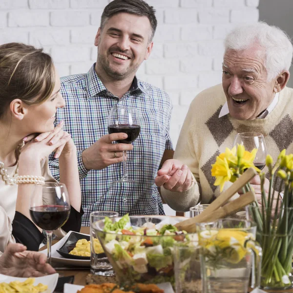 Família feliz sentada ao lado da mesa — Fotografia de Stock