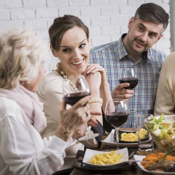 Счастливая семья пьет красное вино во время ужина — стоковое фото