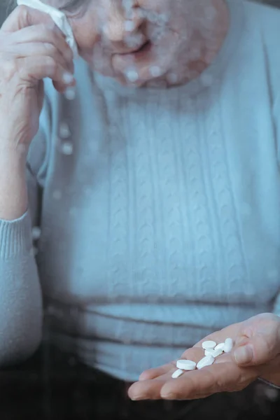 Ältere Dame schaut sich Medikamente an — Stockfoto