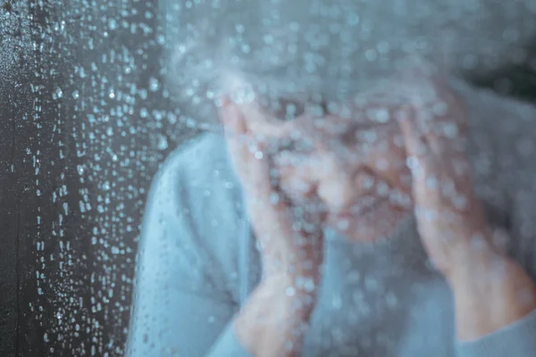 Sad woman behind the glass — Stock Photo, Image