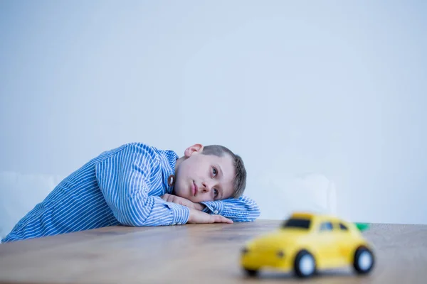 Мальчик и игрушечная машина на столе — стоковое фото