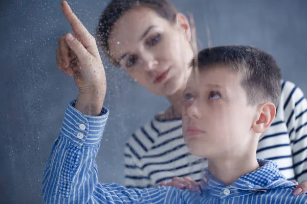 Boy looking through the window — Stock Photo, Image