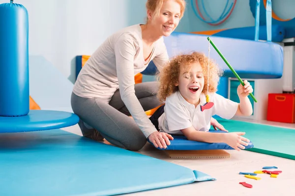 Niño jugando con fisioterapeuta — Foto de Stock