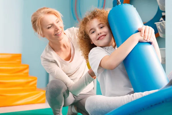 Therapist watching a boy on disc swing — Stock Image Therapist watching a boy on disc swing Stock Image
