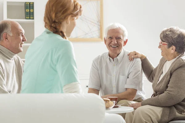 Seniorzy, siedząc z pielęgniarką — Zdjęcie stockowe