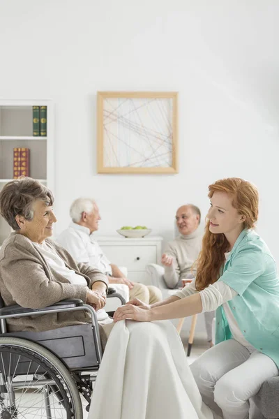 Krankenschwester deckt Seniorin — Stockfoto