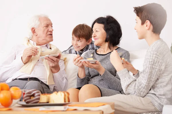 Abuelos comiendo pastel con nietos — Foto de Stock