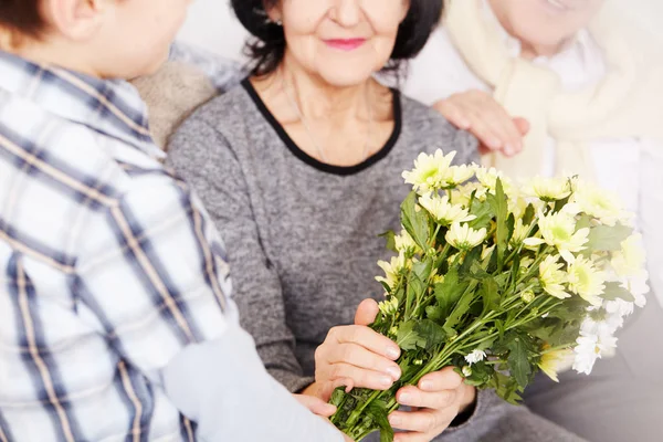 Menino dando flores aos avós — Fotografia de Stock