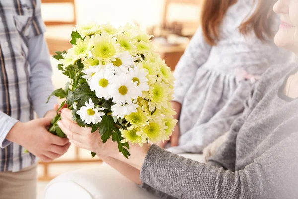 Großmutter bekommt Blumen vom Enkel — Stockfoto