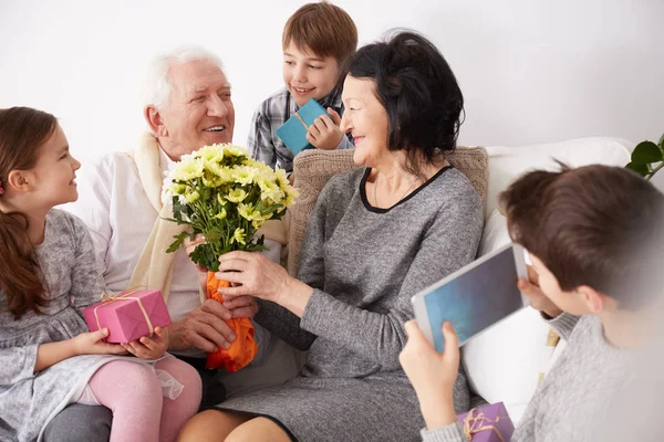 Avós recebendo flores e presentes — Fotografia de Stock