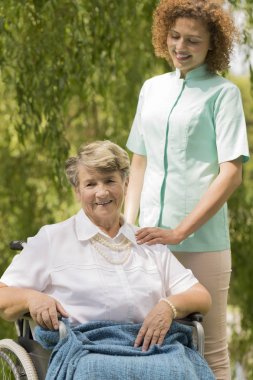 Bir tekerlekli sandalye ve hemşire oturan kadın kıdemli