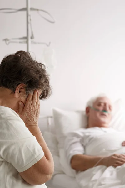 Huilen naast haar zieke man vrouw — Stockfoto