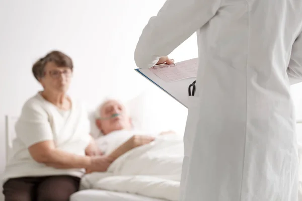 Casal de idosos conversando com médico — Fotografia de Stock