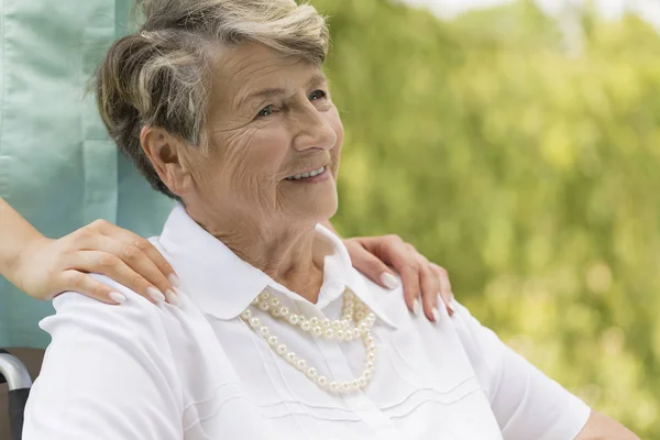 Oudere vrouw zit op een rolstoel — Stockfoto