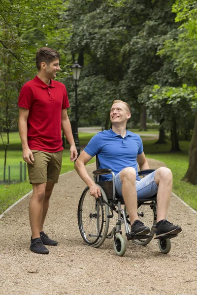 Man in wheelchair spending time with friend — Stock Photo, Image