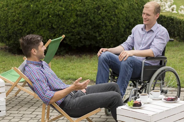 Disabled man drinking coffee with friend — Stock Photo, Image