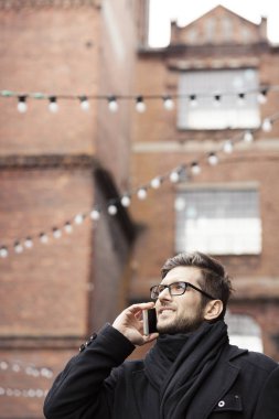 Endüstriyel alanda telefonda konuşan adam