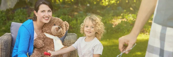 Çocuk ve kadın bahçede oyuncak ayı ile — Stok fotoğraf