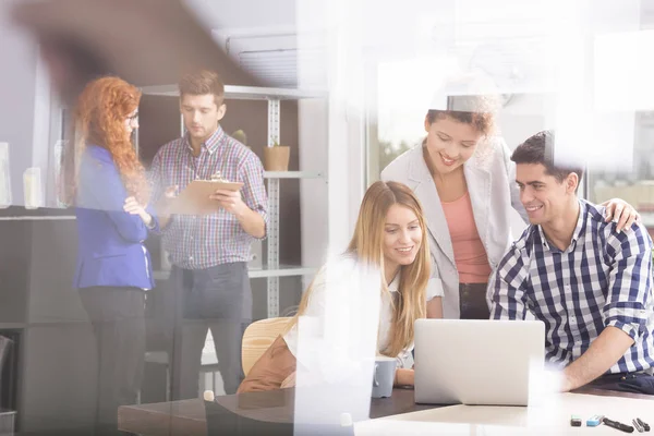 Colaboradores sonrientes usando laptop — Foto de Stock