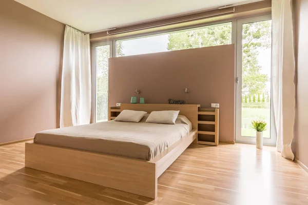 Großes Bett mit beiger Bettdecke — Stockfoto