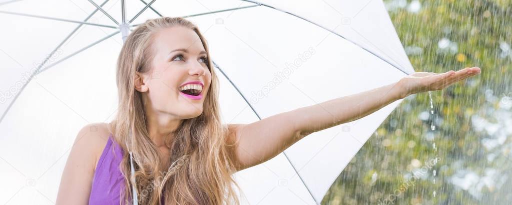 Blonde girl checking if it still rains during stroll