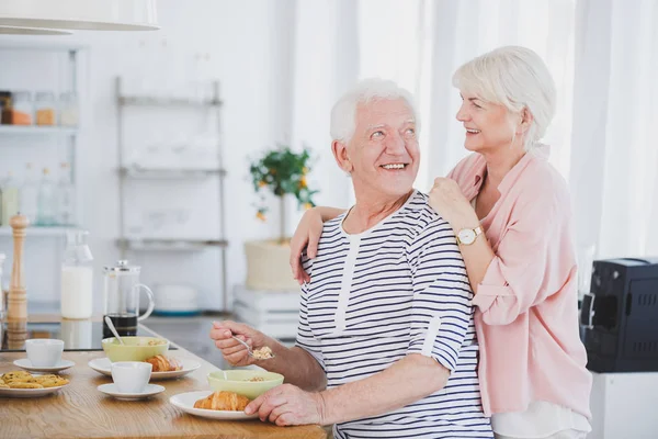 Man eten ontbijt met vrouw achter hem — Stockfoto