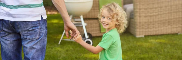 Lachende jongen die vaders hand — Stockfoto