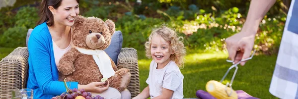 Rapaz sorridente com a mãe no jardim — Fotografia de Stock