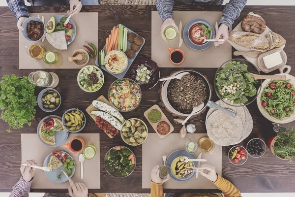 Reunión de amigos en una mesa de madera — Foto de Stock