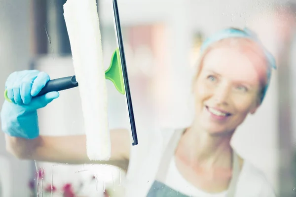 Blondine putzt Fenster — Stockfoto