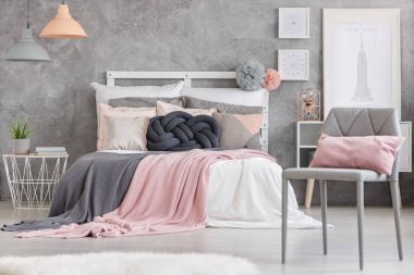Pembe yastık ile gri sandalye