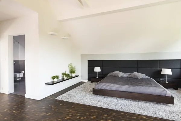 Helles, geräumiges Schlafzimmer mit weißen Wänden — Stockfoto