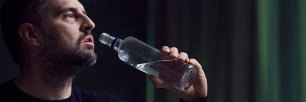 Человек пьет алкоголь из бутылки — стоковое фото