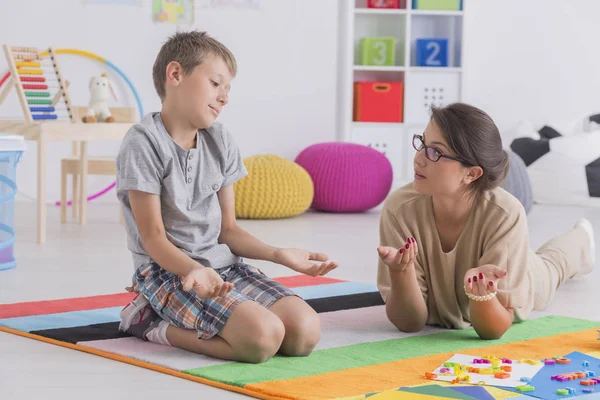 Niño sentado en el suelo encogiéndose de hombros — Foto de Stock