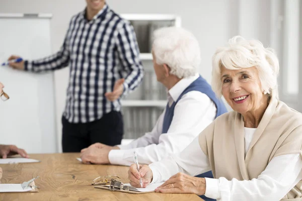 Dam som sitter vid skrivbordet — Stockfoto