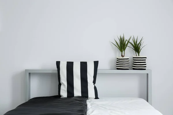 Полосатая подушка на черно-белом покрывале — стоковое фото