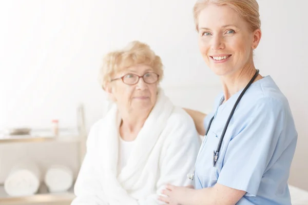 Senior dame in huis met verpleegkundige — Stockfoto