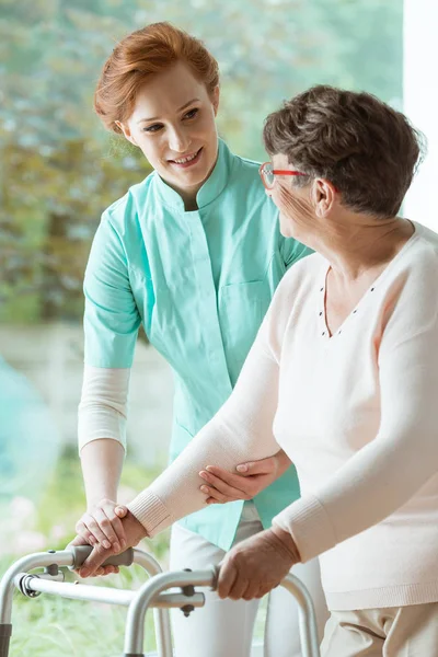 Nurse helping elder with walker — Stock Photo, Image