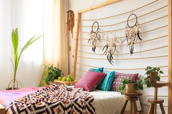 Bed with bedhead with dreamcatchers — Stock Photo, Image