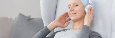 Woman with cancer listening to music clipart
