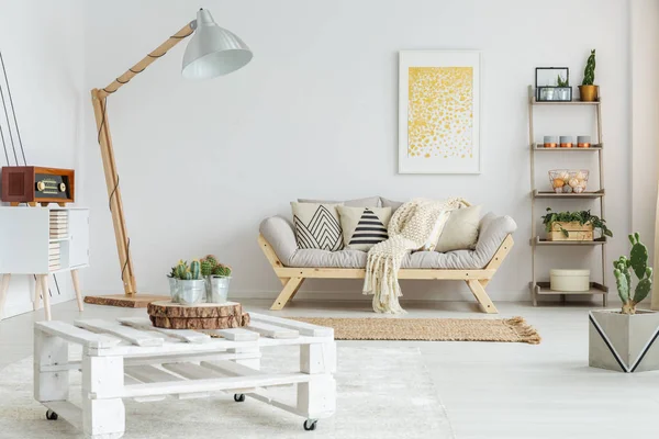 Дерев'яна полиця поруч з дизайнерським диваном — стокове фото
