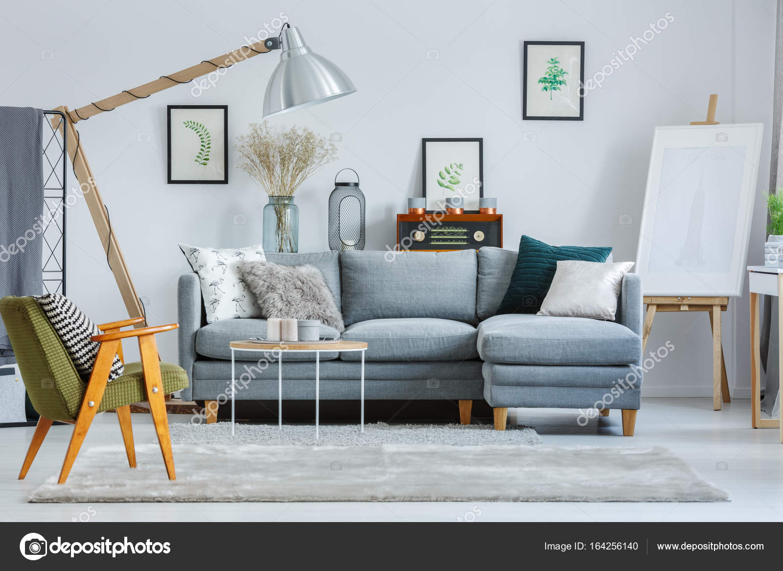 Green Armchair In Living Room Stock Photo Photographee Eu 164256140 Classic Green Armchair In Living Room With Easel And Design Lamp Above Grey Sofa Pillows Photo By Photographee Eu